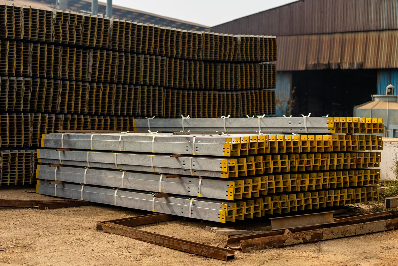 services-02 Stacked metal beams in an industrial yard, ideal for construction and architecture themes.